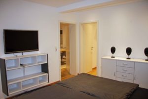 Schlafzimmer mit Doppelbett, hochwertigen Kaltschaummatrazzen und Sideboards. ANDERS CONSULTING Relocation Service Düsseldorf