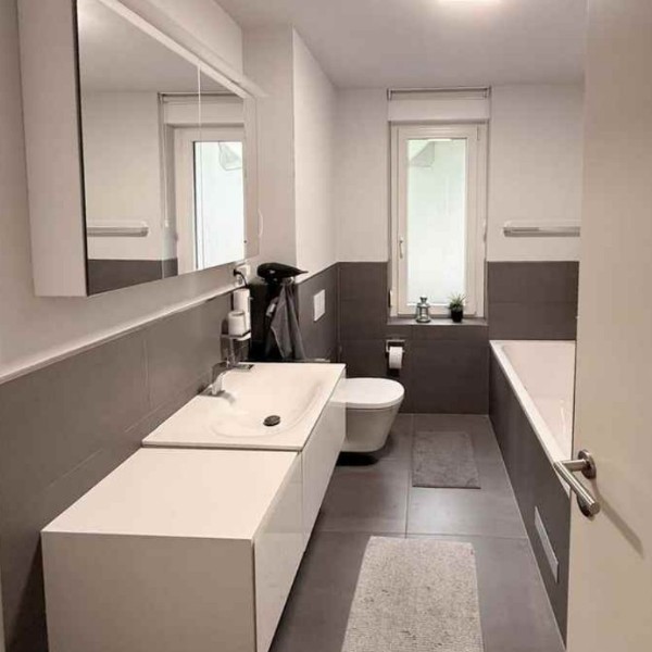 Modernes Badezimmer mit Keuco-Armaturen, Badewanne und separatem WC-Bereich – 4-Zimmer-Wohnung Westhafen Frankfurt