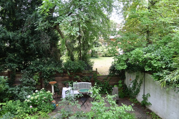 Gepflegter Garten mit Sitzecke und Bistrotisch der möblierten Altbauwohnung zur Miete auf Zeit in Berlin