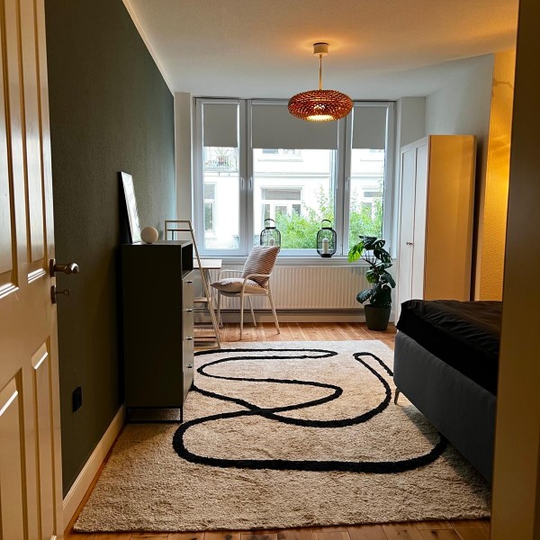 Gemütliches Schlafzimmer mit einem flauschigen Teppich in einer Altbauwohnung in Lübeck