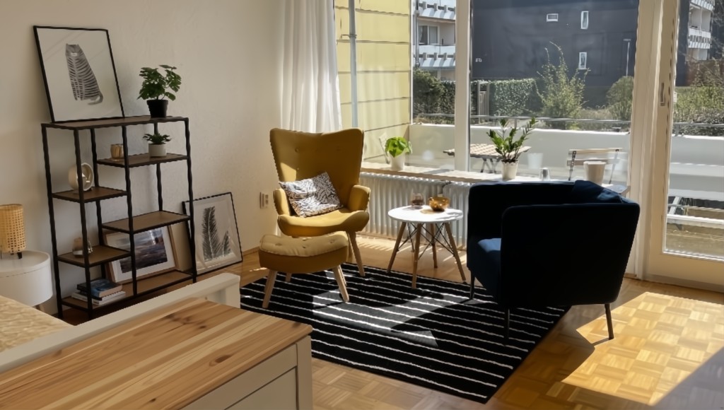 Helles Wohnzimmer mit Sesseln, Teppich und Balkonzugang in möblierter Wohnung Braunschweig-Lehndorf
