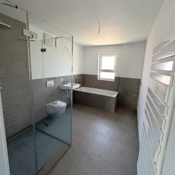 Modernes Badezimmer mit begehbarer Dusche, Badewanne, Waschbecken und Handtuchheizkörper